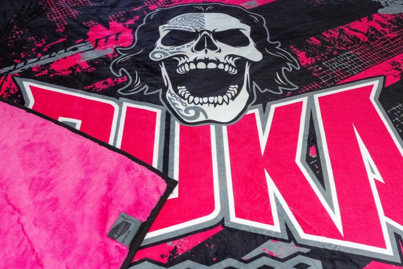 Edge-to-edge photo-realistic skull design print with the plush pink reverse side folded over